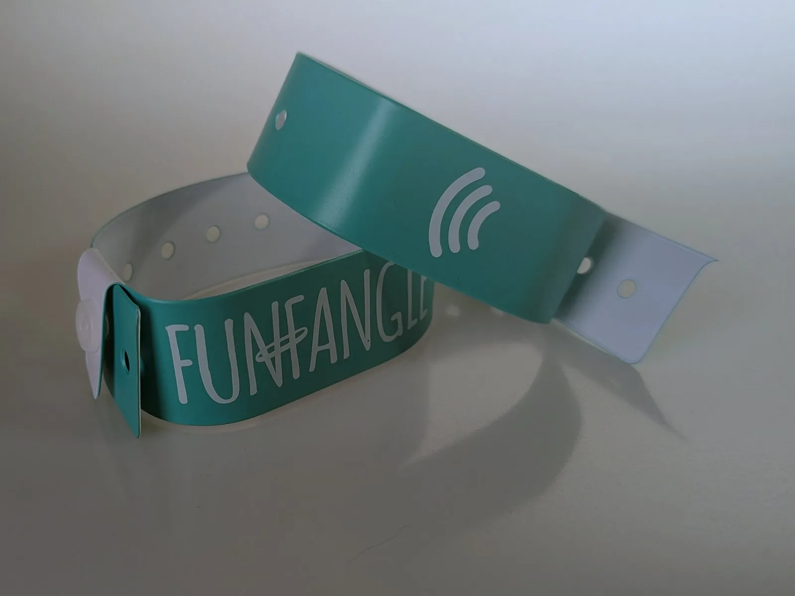 Two green vinyl Snap and Go wristbands printed with the FunFangle wordmark and tap mark